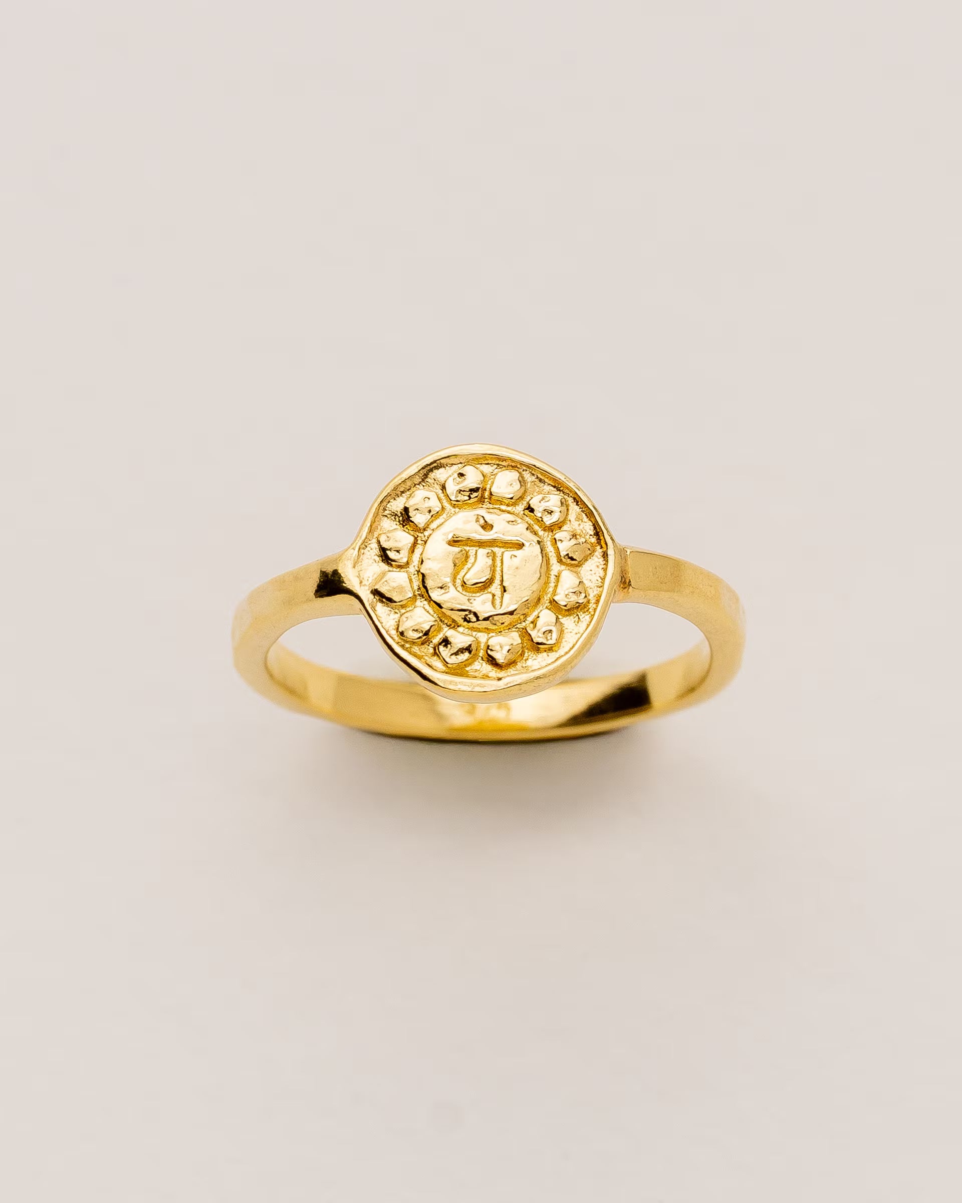 #Motiv_Anahata CHAKRA ANAHATA RING GOLD – Dieser handgefertigte Siegelring von ILUH aus Bali im minimalistischen Stil überzeugt durch eine runde, strukturierte Platte, die das originale Sanskrit-Zeichen für das Anahata-Herzchakra zeigt; eingebettet in kunstvolle Lotusblütenblätter dient er als kraftvolles Symbol zur Stärkung deines Energiezentrums.