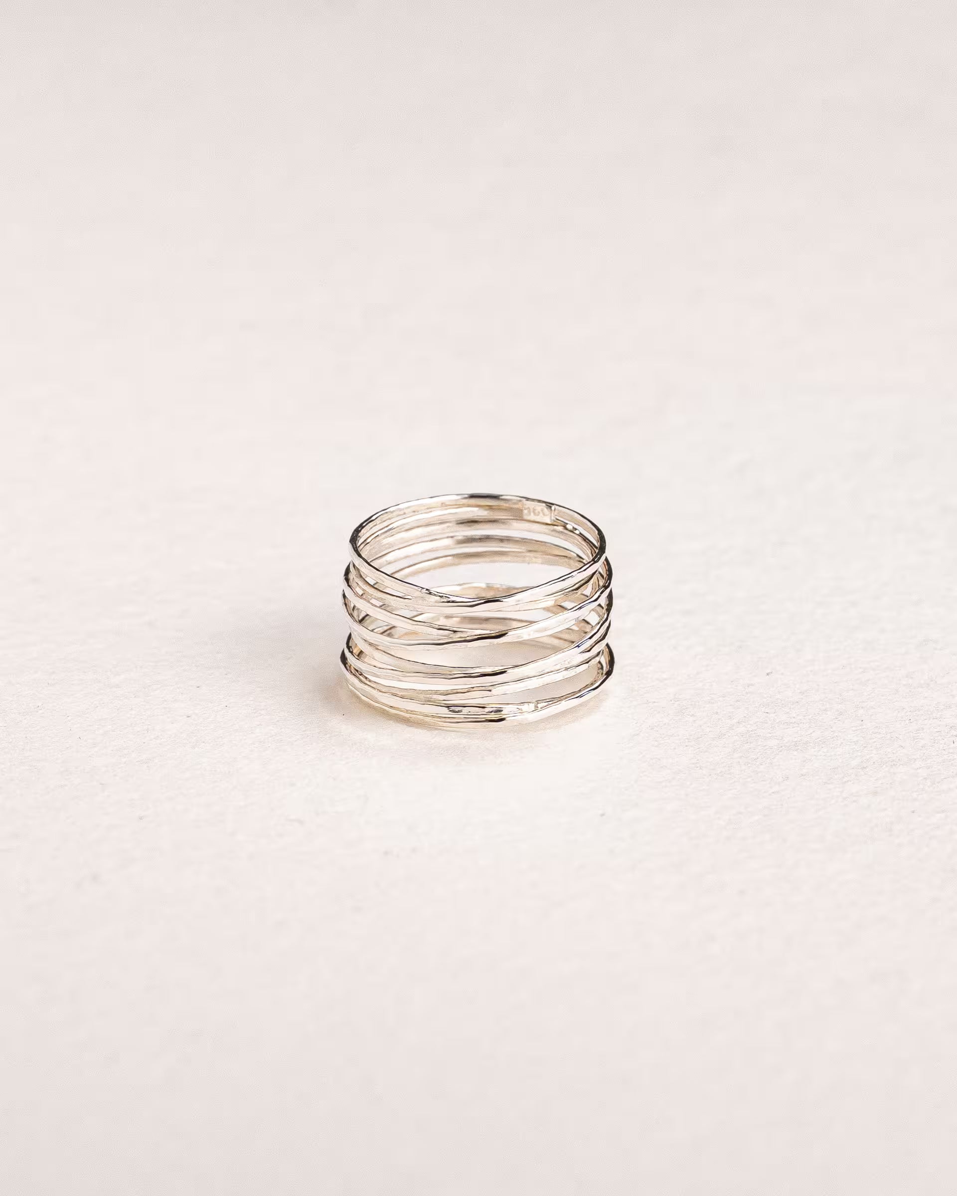 AURA RING SILBER Produktbild – Diese Nahaufnahme zeigt einen zarten Aura-Ring von der Schmuckmarke ILUH aus Bali in einem cleanen Design; das Schmuckstück besticht durch seinen kunstvoll gewickelten Silberfaden in einem eleganten Wickeldesign mit gehämmerter Struktur.