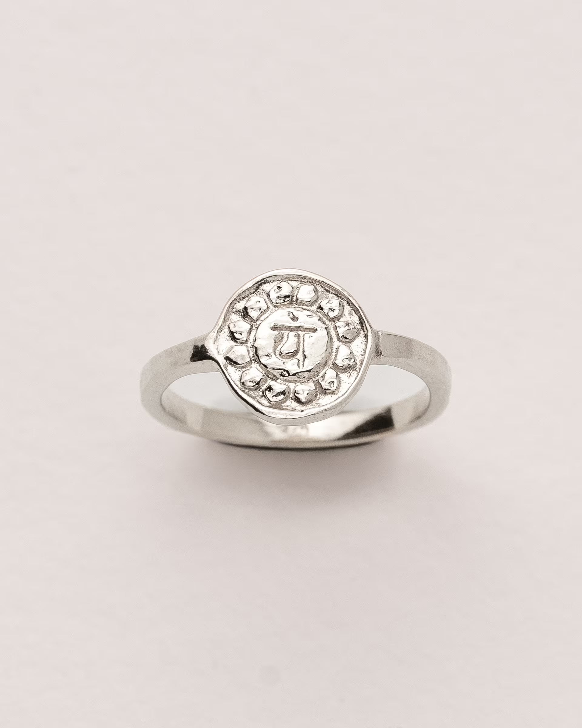 #Motiv_Anahata CHAKRA ANAHATA RING SILBER – Dieser handgefertigte Siegelring von ILUH aus Bali im minimalistischen Stil überzeugt durch eine runde, strukturierte Platte, die das originale Sanskrit-Zeichen für das Anahata-Herzchakra zeigt; eingebettet in kunstvolle Lotusblütenblätter dient er als kraftvolles Symbol zur Stärkung deines Energiezentrums.