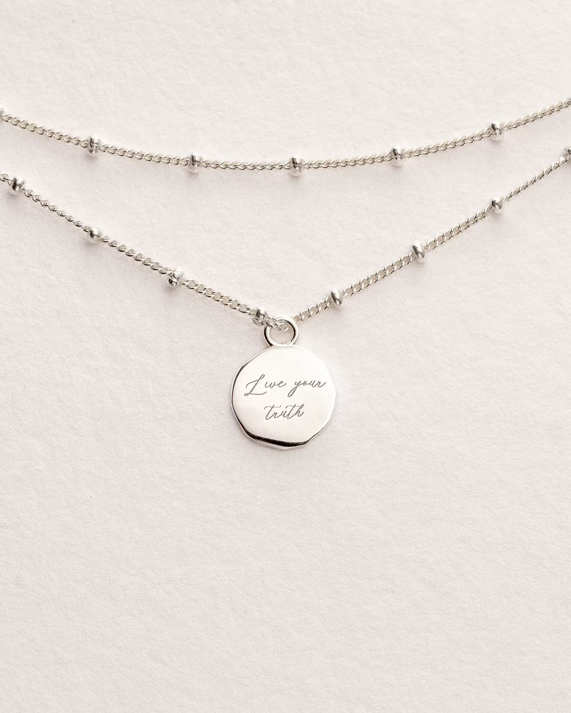 Filigranes ILUH Chakra-Armband in 925er Sterlingsilber mit graviertem Anhänger ‚Live your truth‘; eine Hommage an das Vishuddha-Chakra (Halschakra), das für authentische Kommunikation und innere Wahrheit steht. Minimalistisches, feminines Design, handgefertigt in Bali.