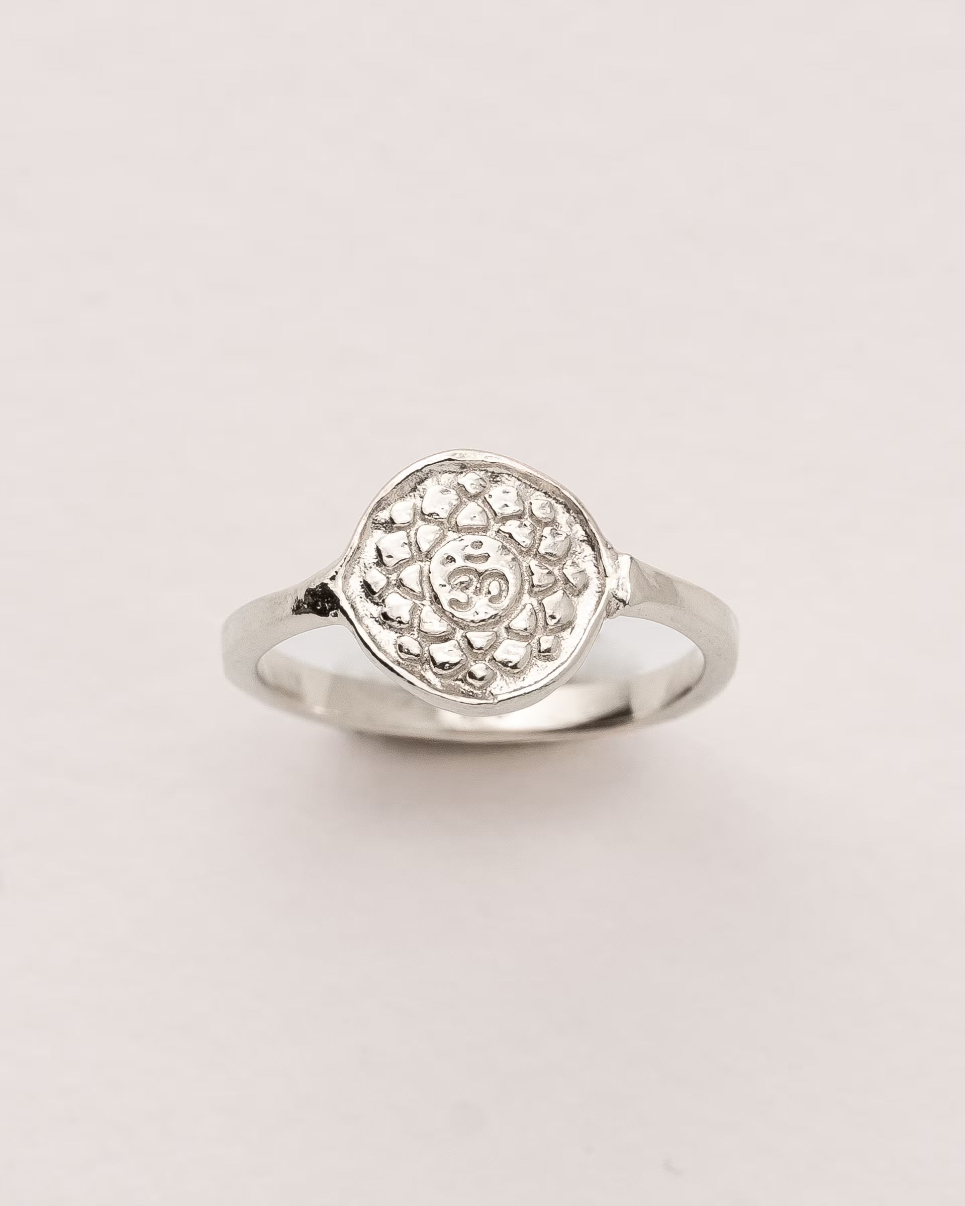 #Motiv_Sahasrara CHAKRA SAHASRARA RING SILBER  – Dieser handgefertigte Siegelring von ILUH aus Bali im minimalistischen Stil überzeugt durch eine runde, strukturierte Platte, die das originale Sanskrit-Zeichen für das Sahasrara-Kronenchakra zeigt; eingebettet in kunstvolle Lotusblütenblätter dient er als kraftvolles Symbol zur Stärkung deines Energiezentrums.