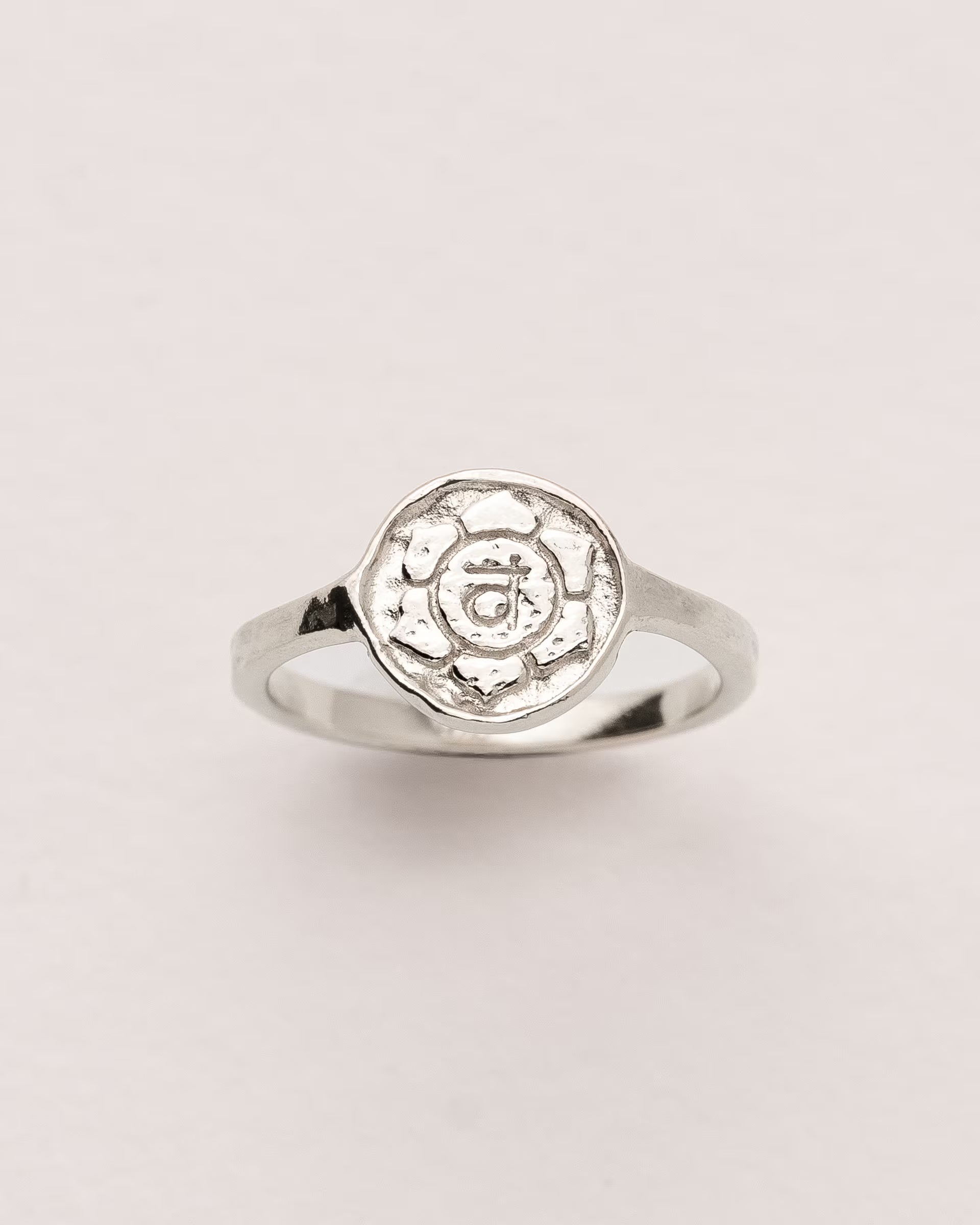 #Motiv_Svadhisthana CHAKRA SVADHISTHANA RING SILBER – Dieser handgefertigte Siegelring von ILUH aus Bali im minimalistischen Stil überzeugt durch eine runde, strukturierte Platte, die das originale Sanskrit-Zeichen für das Svadhisthana-Sakralchakra zeigt; eingebettet in kunstvolle Lotusblütenblätter dient er als kraftvolles Symbol zur Stärkung deines Energiezentrums.